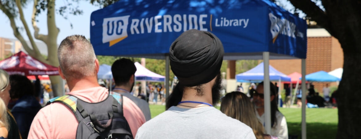 Image of people surrounding the UCR Library tent during Highlander Orientation