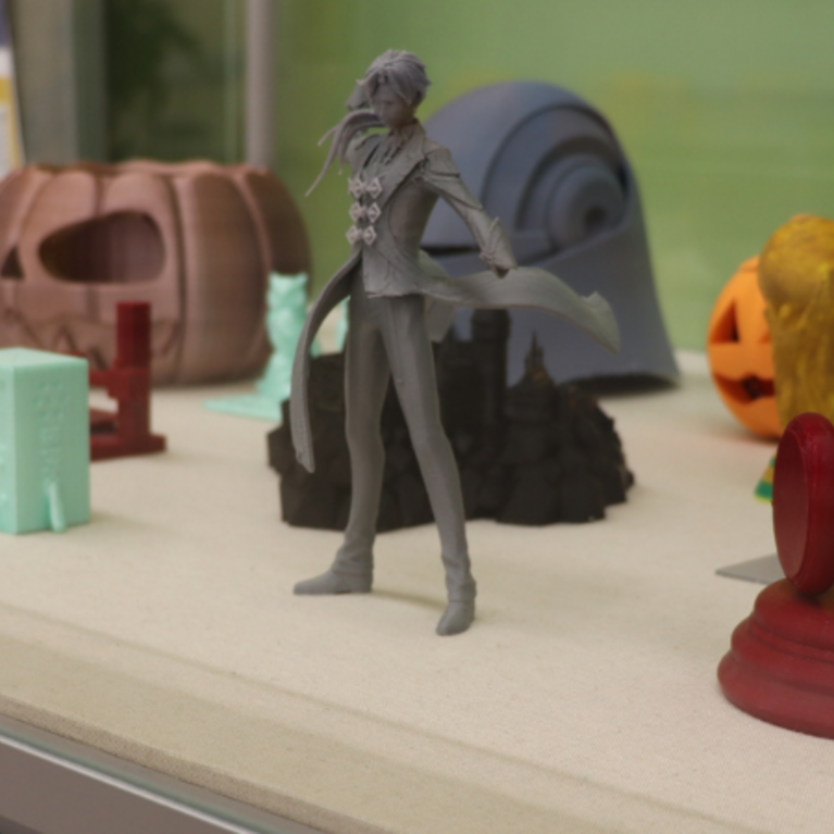 Layer by Layer display case showcasing 3D printed objects. 