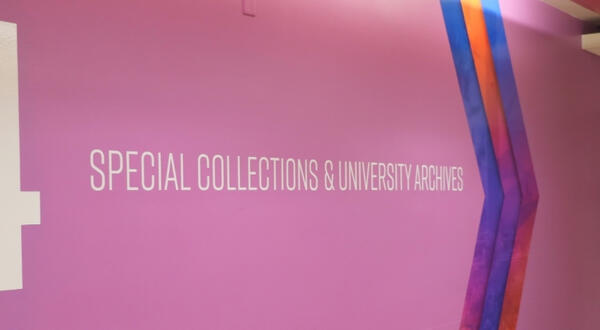 Large white number 4 and text reading "SPECIAL COLLECTIONS & UNIVERSITY ARCHIVES" on a bright purple wall with diagonal blue and orange chevron accents.