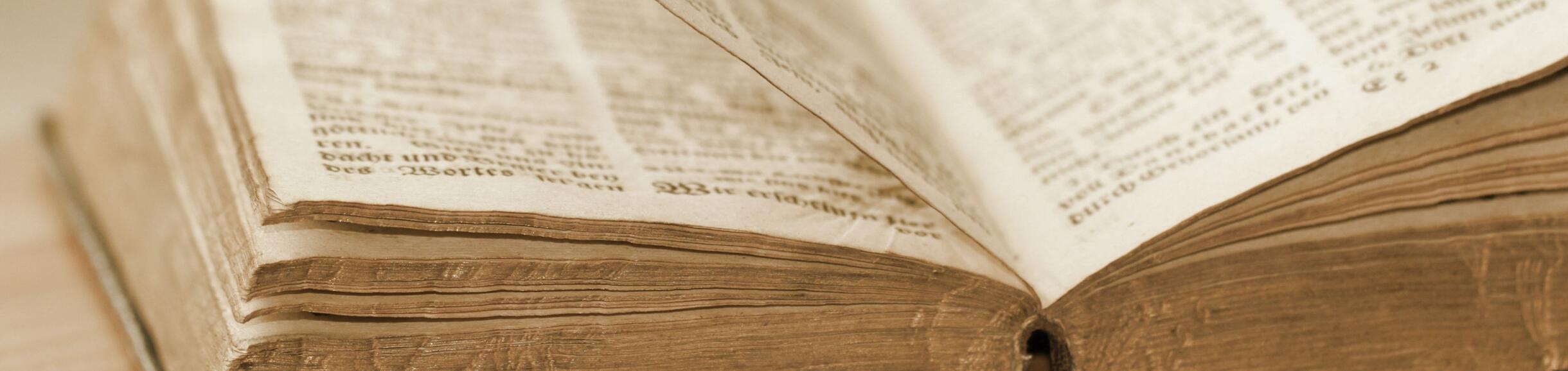 older open book laying flat on a surface